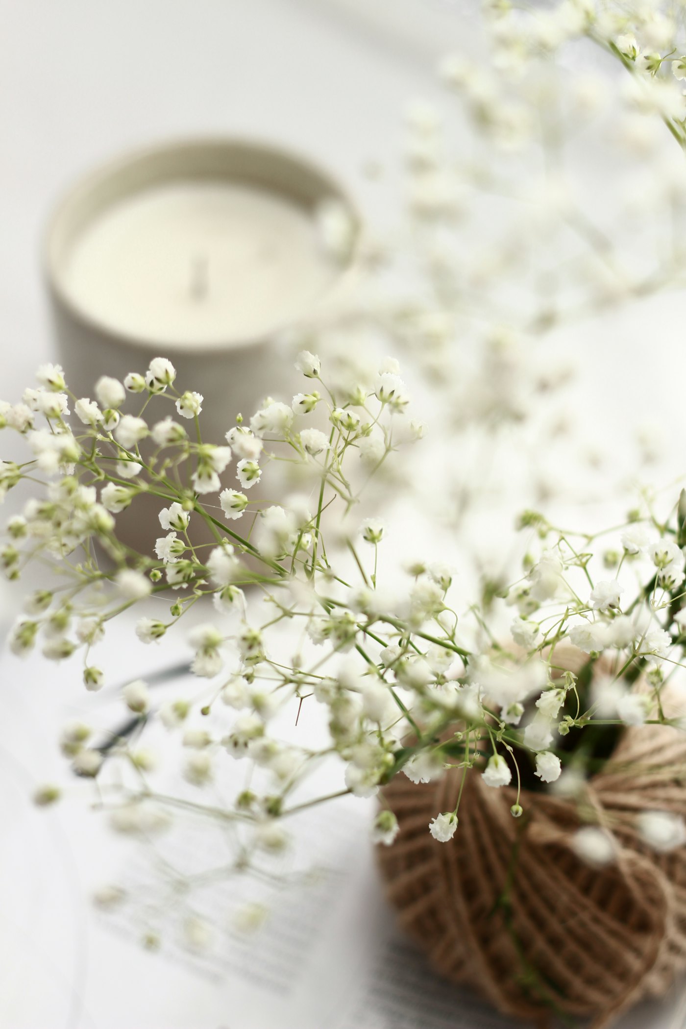 Gypsophila ve váze vedle bílé svíčky